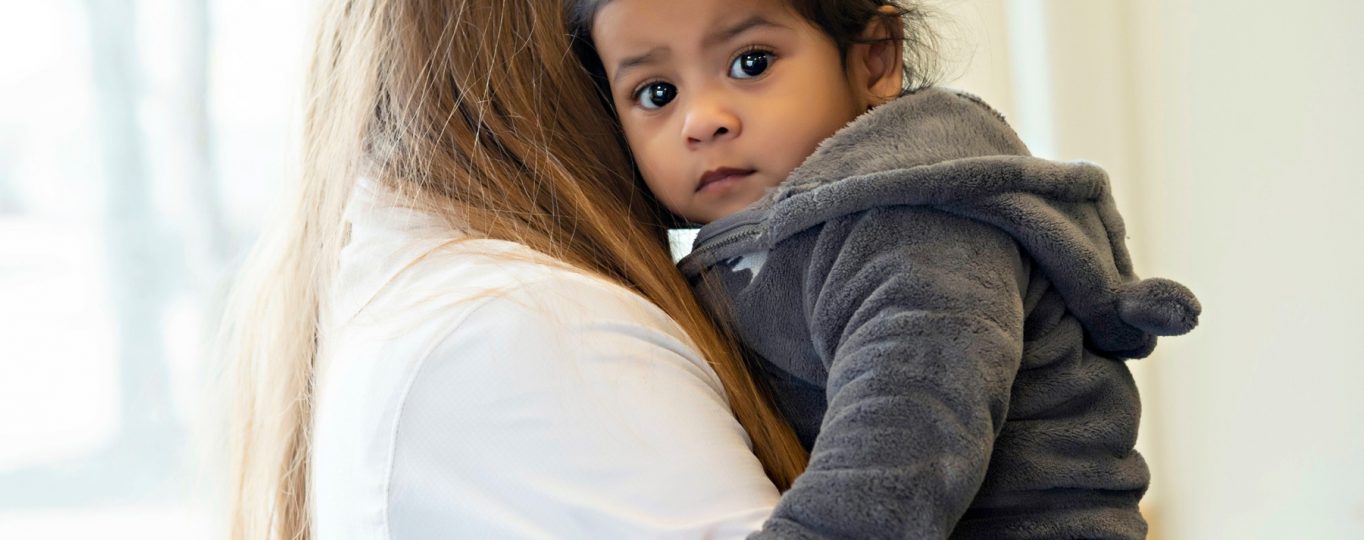 A small child is being held by an an adult female