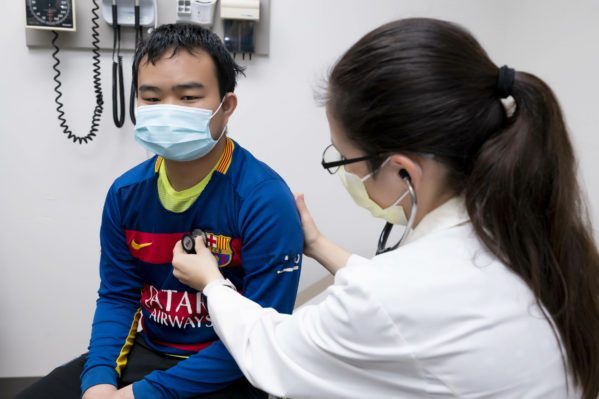Dr. Menning listens to patient's heart and lungs during a check-up.