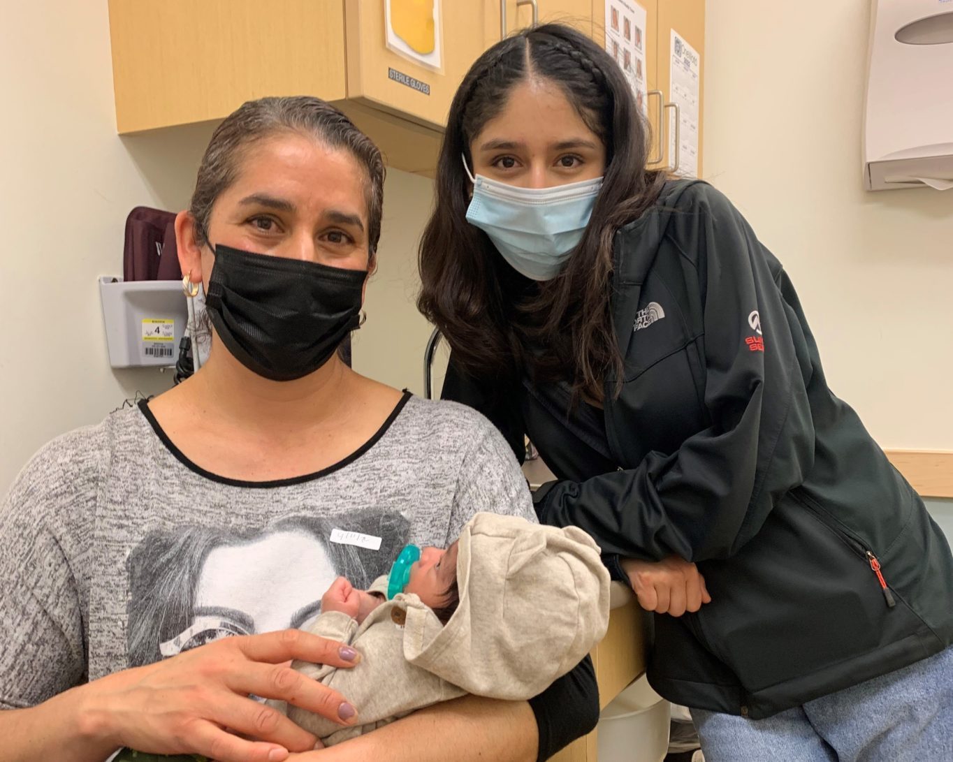 A person with a baby wearing face masks