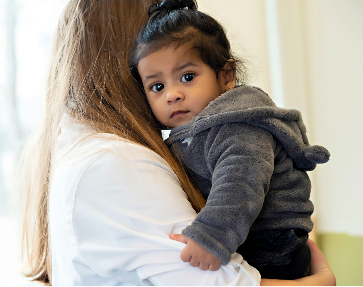 Thiago being held by Wesley Milligan, Social Worker.