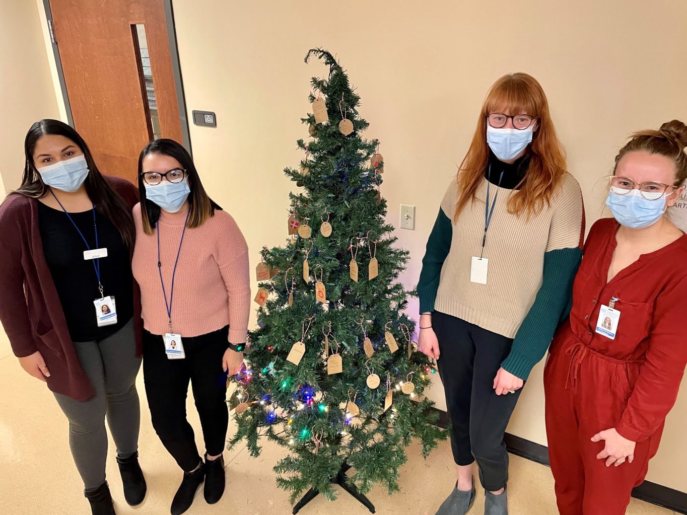 Members of the social work team around the holiday tree.