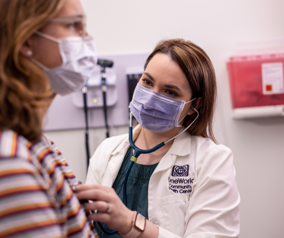 A person wearing a mask and stethoscope listening to a patient