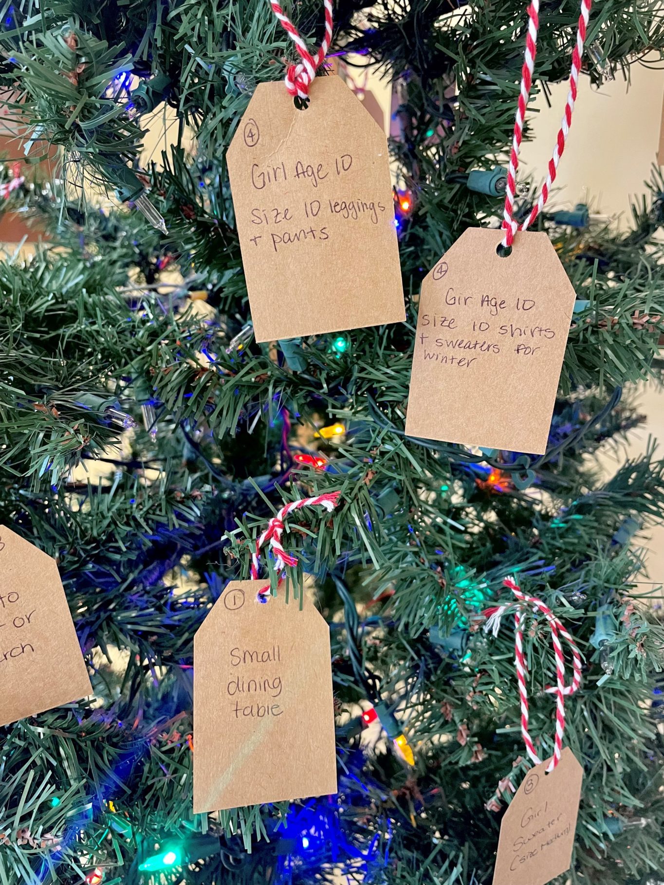 Wish list tag ornaments hanging on holiday tree.