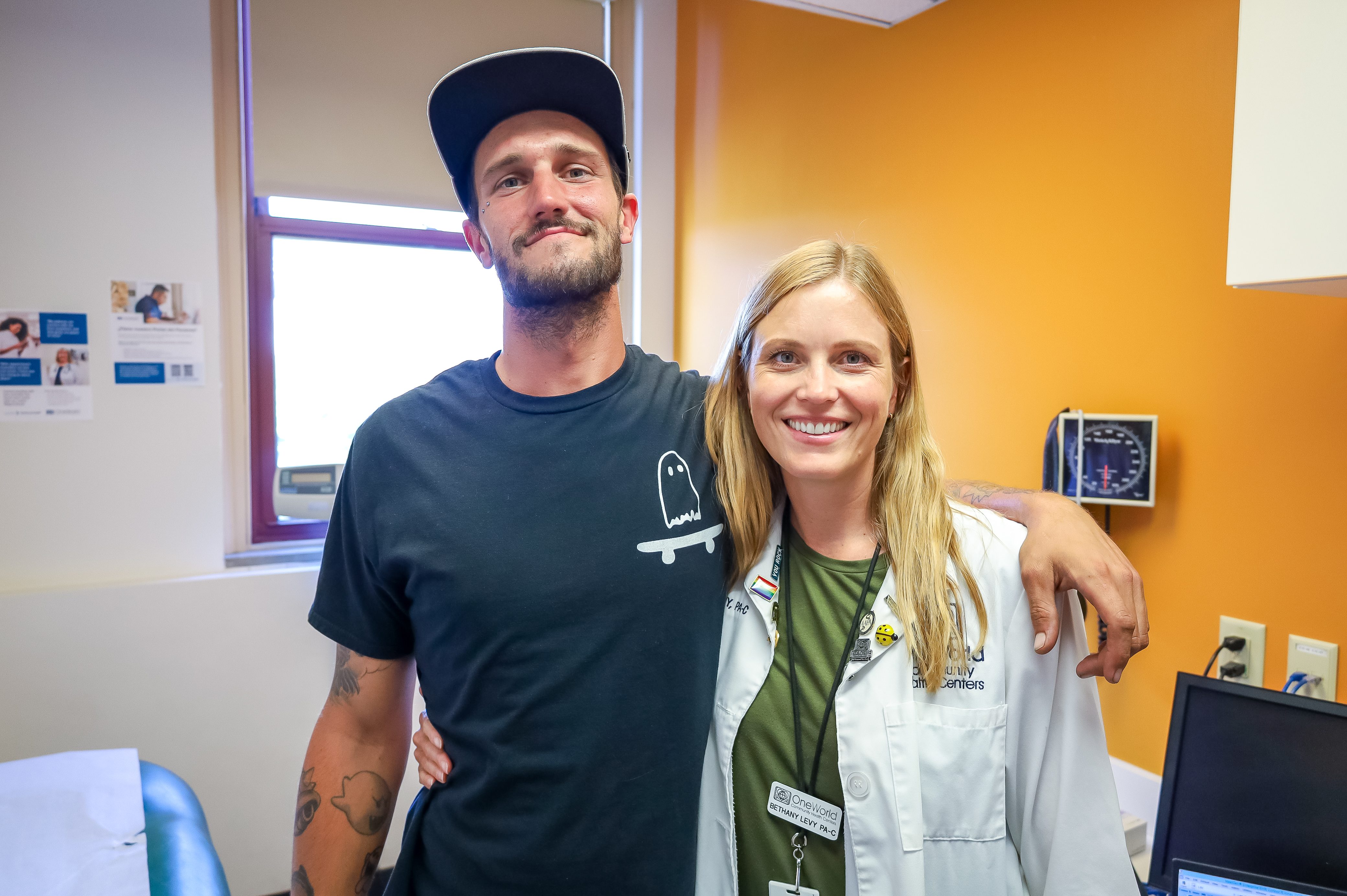 A female provider posing for a picture with a male patient.