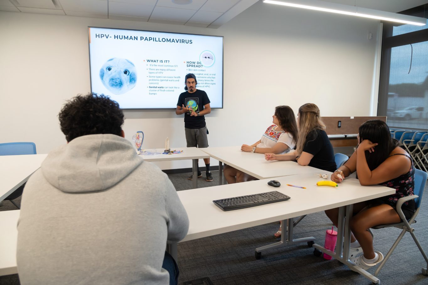 Luis Vazquez, Adolescent Health Outreach Manager, teaches Omaha Teen Generation (OTG) group members inside a classroom.