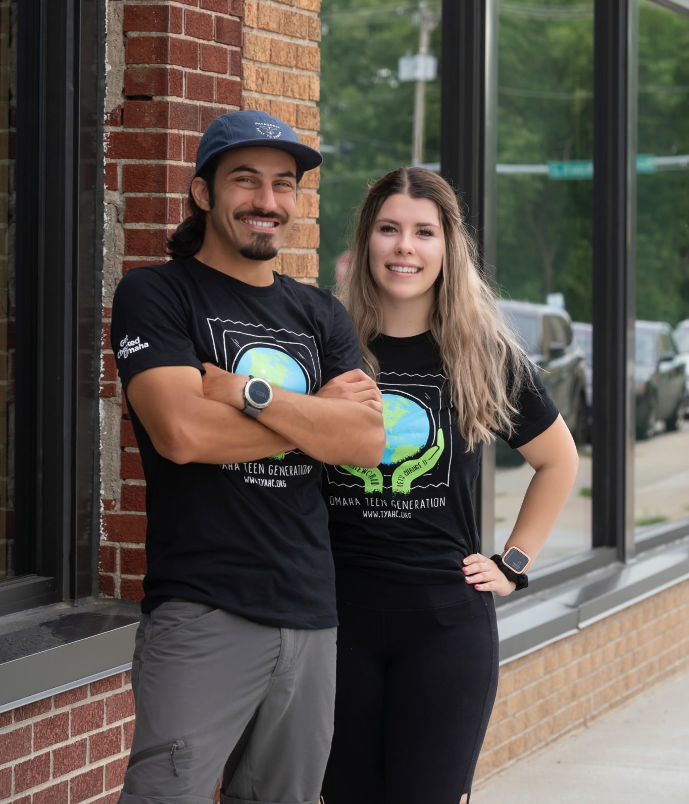 Luis Vazquez, Adolescent Health Outreach Manager, and Ericka Alvarez, Adolescent Health Educator stand outside a clinic smiling.