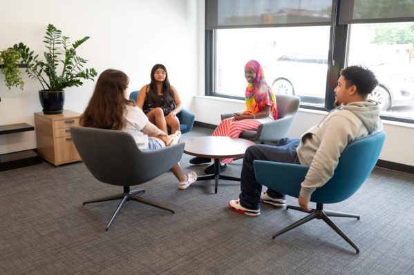 Four teens sitting around a coffee table.