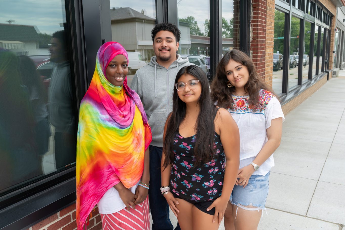 Four teens standing outside of a clinic smiling