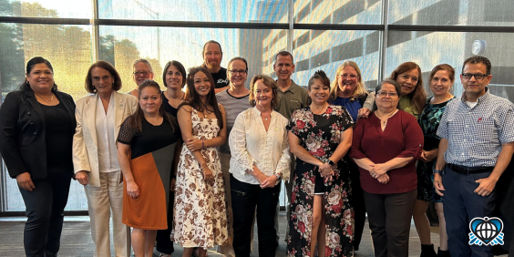 A group of OneWorld employees stand and smile. They are celebrating milestone anniversaries.
