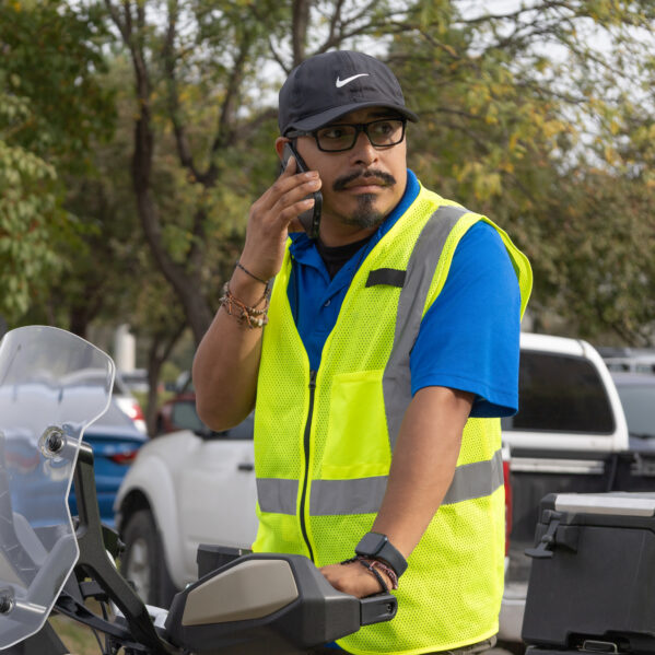 OneWorld Facilities Maintenance Manager Antonio Degante takes a phone call while sitting atop an ATV.